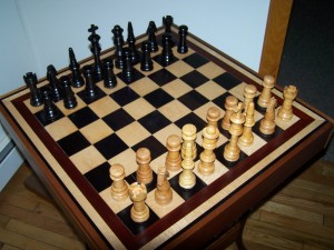 Ebony and Curly Maple chess board with matching chess pieces. trimmed in bloodwood.