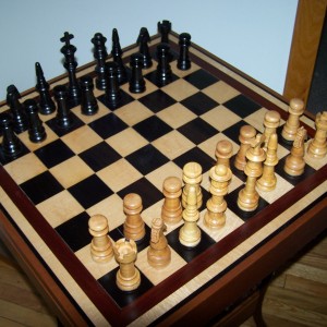 Ebony and Curly Maple chess board with matching chess pieces. trimmed in bloodwood.