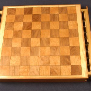 Chess board with walnut and cherry and a black veneer highlight which is accented by an ash trim.