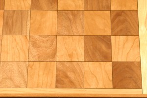 Chess board with walnut and cherry and a black veneer highlight which is accented by an ash trim.