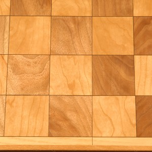 Chess board with walnut and cherry and a black veneer highlight which is accented by an ash trim.