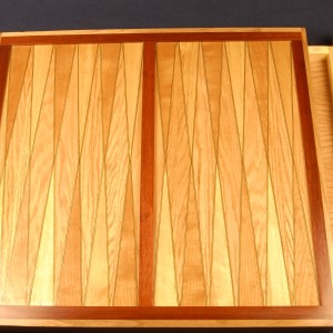 Oreo design. Two darker veneers with a lighter one in between. This backgammon board is of cherry, birch and red oak.